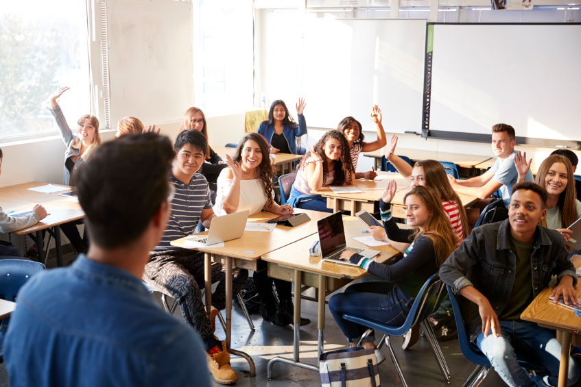 Lehrer vor Klasse, Schülerinnen und Schüler mit Tablets