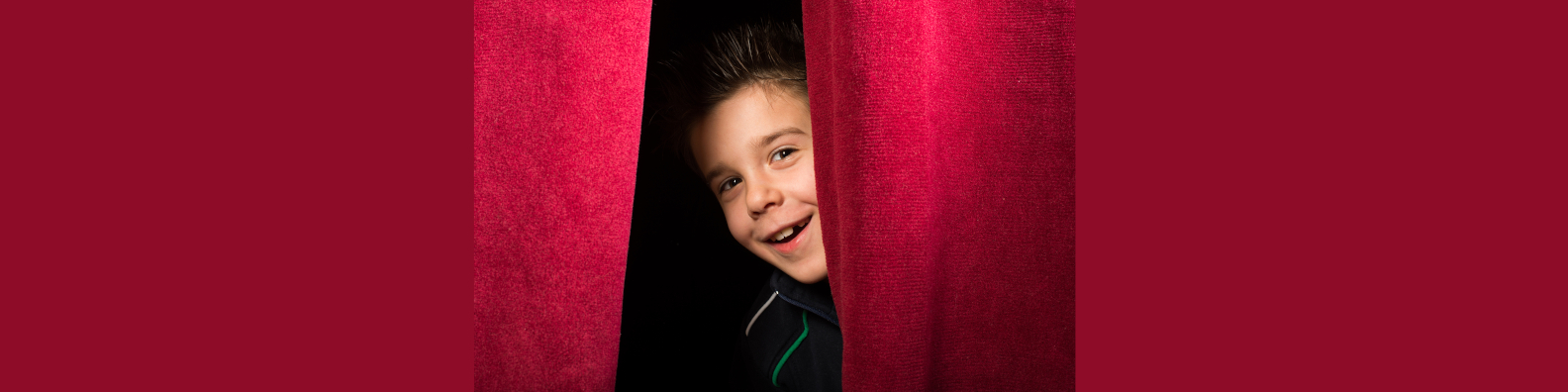 Bild: Schüler schaut hinter Theatervorhang heraus