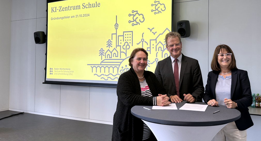 Foto von der Eröffnung des KI-Zentrums Schule in Heilbronn am 21. Oktober 2024: von links nach rechts stehen Kultusministerin Theresa Schopper, ZSL-Präsident Prof. Dr. Thomas Riecke-Baulecke und die Geschäftsführerin der Dieter Schwarz Stiftung, Silke Lohmiller an einem Stehtisch. Im Hintergrund ist eine gelbe Power-Point-Präsentationsfolie mit dem Text „KI-Zentrum Schule. Gründungsfeier am 21.10.2024“, einer Strichzeichnung und dem ZSL-Logo zu sehen.