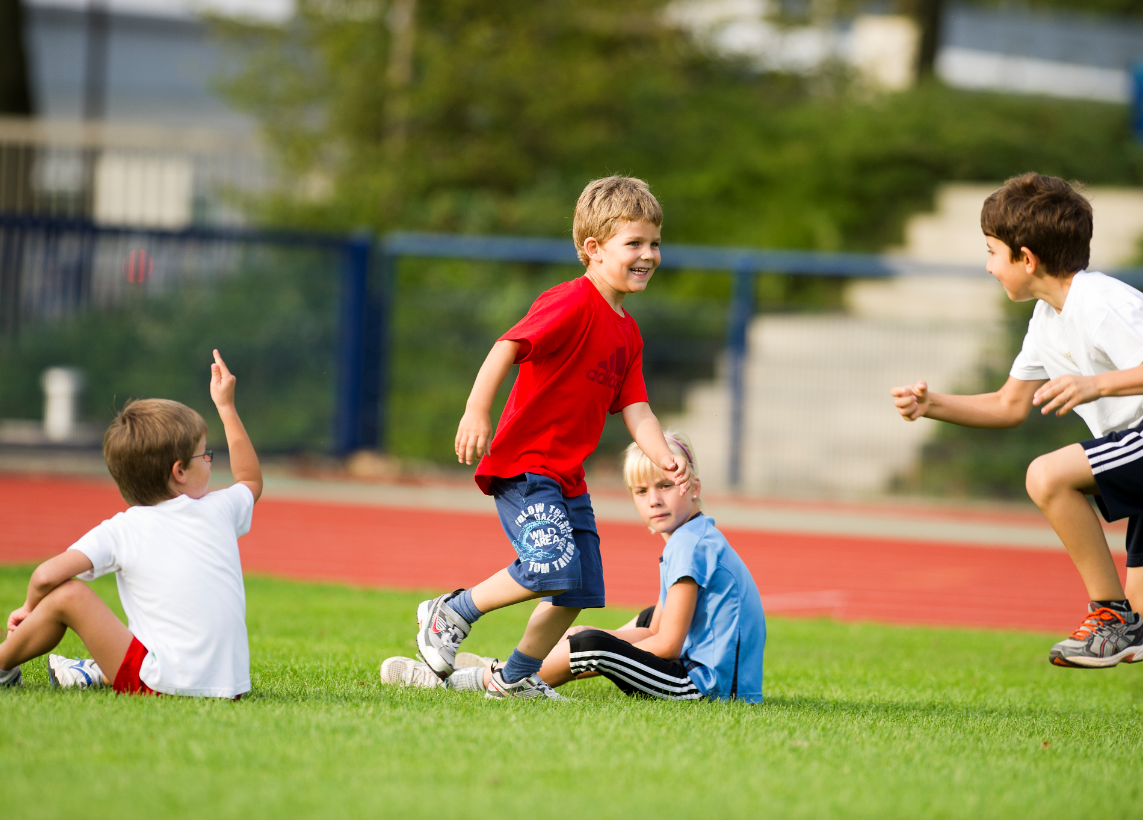 Foto: Kinder beim Schulsport auf dem Rasen