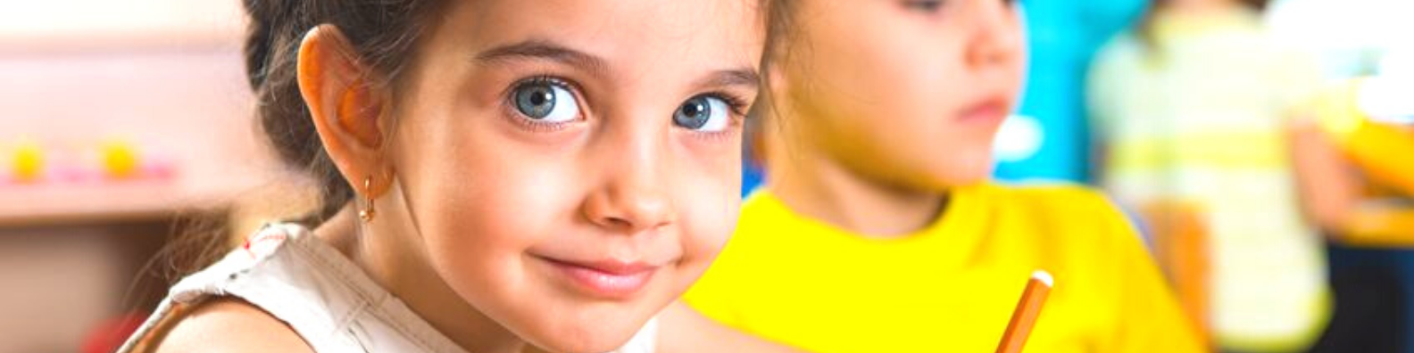 Foto: zwei Kinder im Grundschulunterricht: Mädchen im Vordergrund, Junge im Hintergrnd