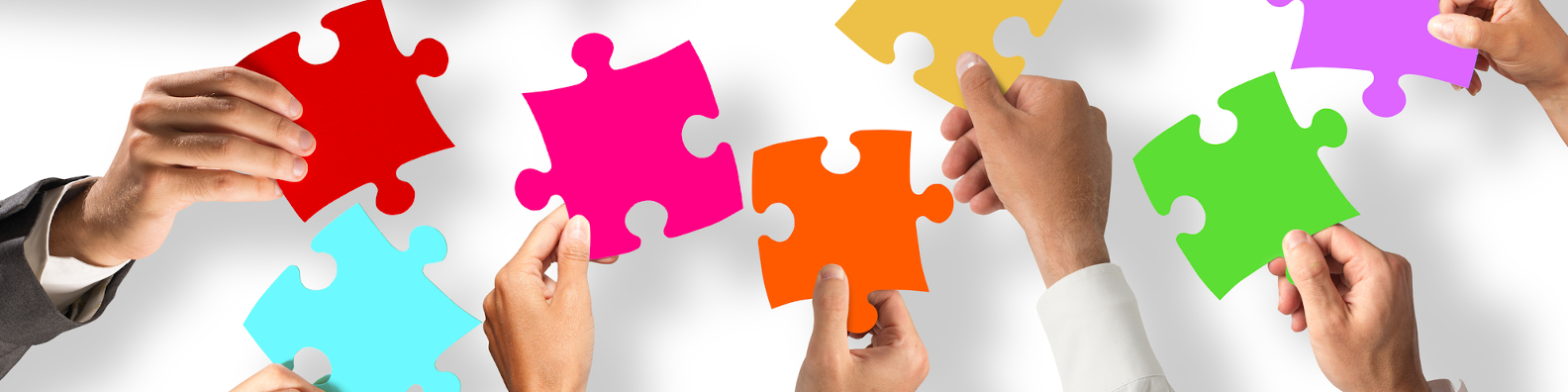 Foto: viele Hände fügen Puzzleteile zusammen