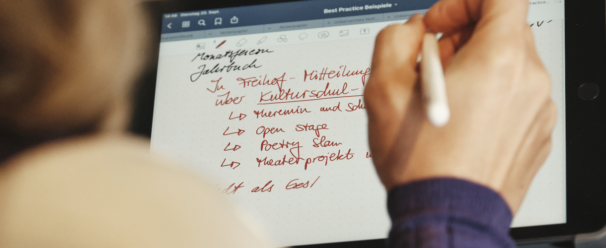 Foto: Eine Hand mit Stift fertigt Notizen zur Kulturellen Bildung auf einem Tablet an.