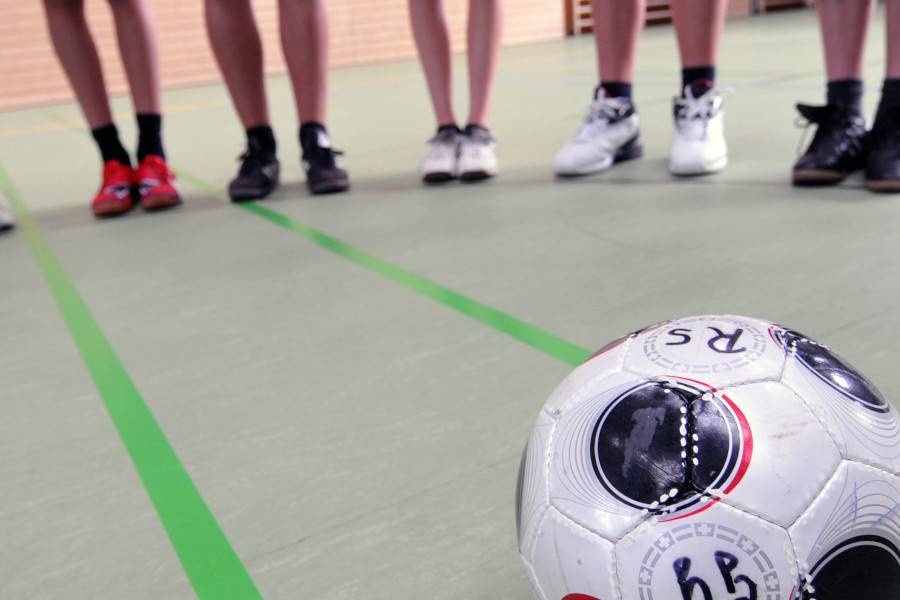 Link zur ZSL-Seite „Sport“; Foto: In einer Sporthalle liegt ein Fußball auf dem Boden.