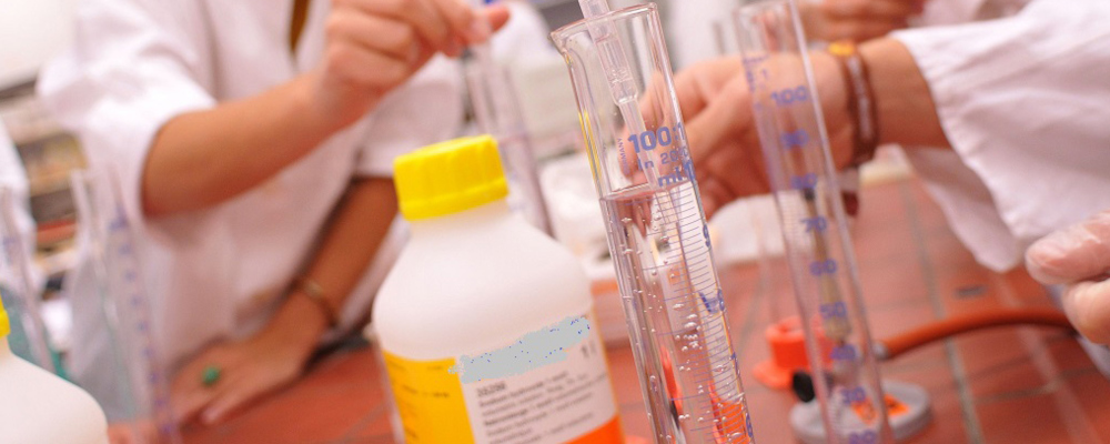 Foto: Auf einem Experimentiertisch stehen Standzylinder und Chemikalienflaschen. 