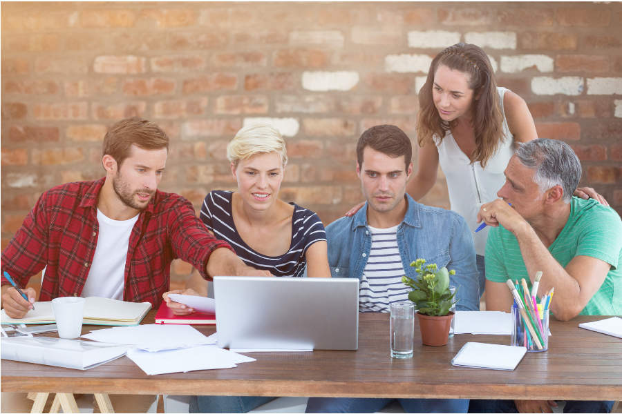 Link; Symbolbild für Unterstützung durch Fachberaterinnen und Fachberater Schulentwicklung (FBS) (Foto: Fünf Erwachsene sitzen an einem Tisch, schauen auf Laptop und Unterlagen und arbeiten gemeinsam in einer Lern- oder Teamsituation.)