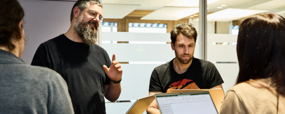 Symbolbild für Fortbildung (Foto: Gruppe von drei jungen Menschen, die einem Fortbildner zuhört)