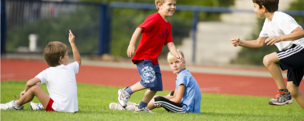 Foto: Kinder beim Schulsport auf dem Rasen