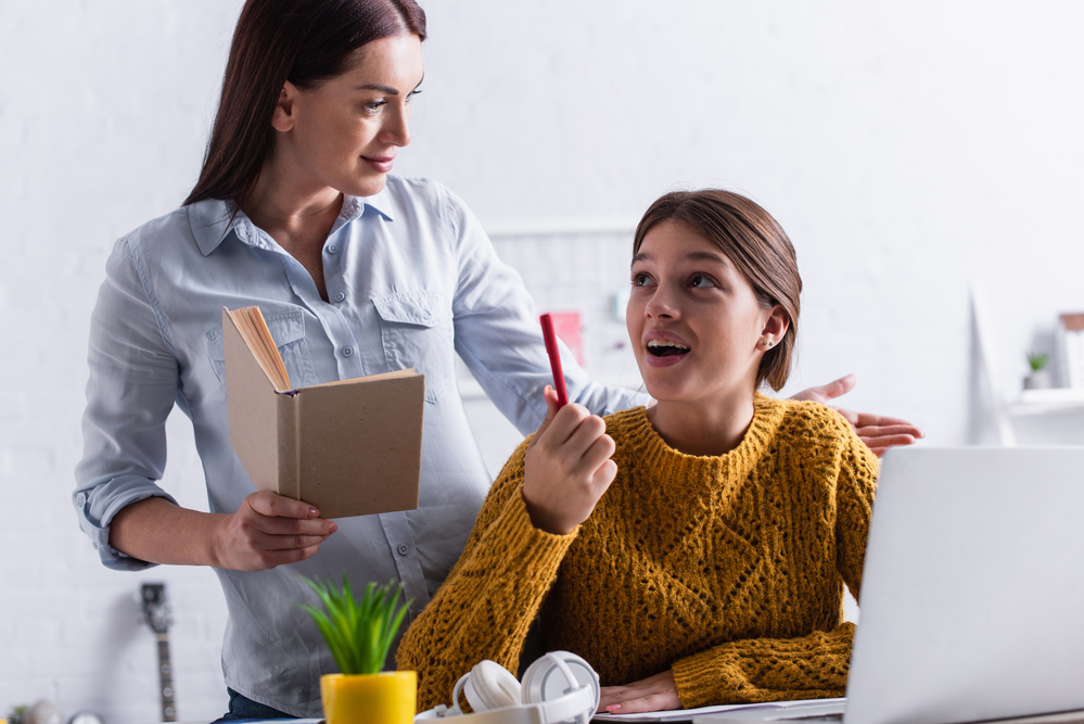 Kleiner Junge sitzt auf Boden und schreibt am Laptop