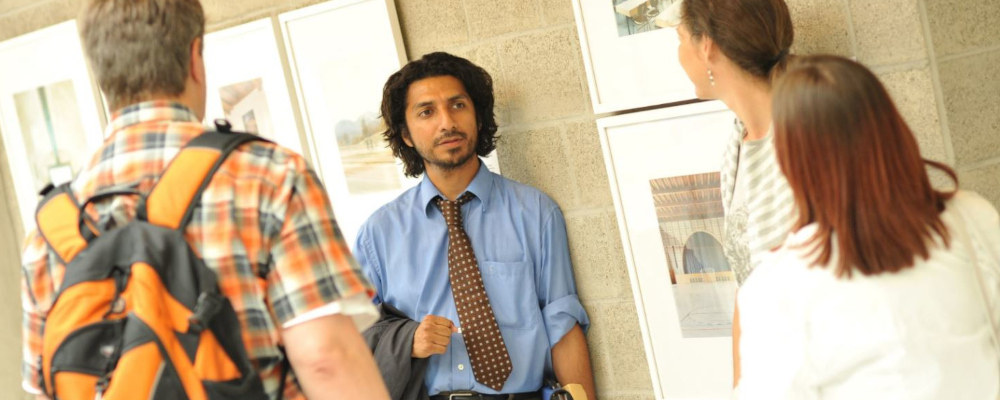 Symbolbild: Vier Lehrkräfte unterhalten sich auf dem Gang.