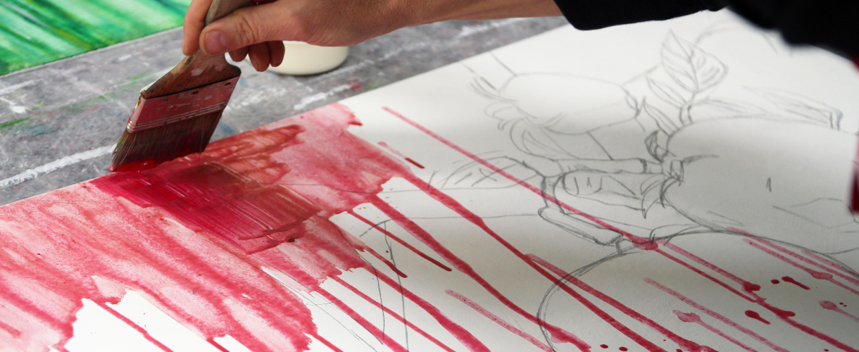 Foto: Eine Hand trägt mit einem breiten Pinsel rote Farbe auf ein Blatt mit Bleistiftzeichnung auf, wodurch vertikale Farbläufe entstehen – Teil eines malerischen Experiments.