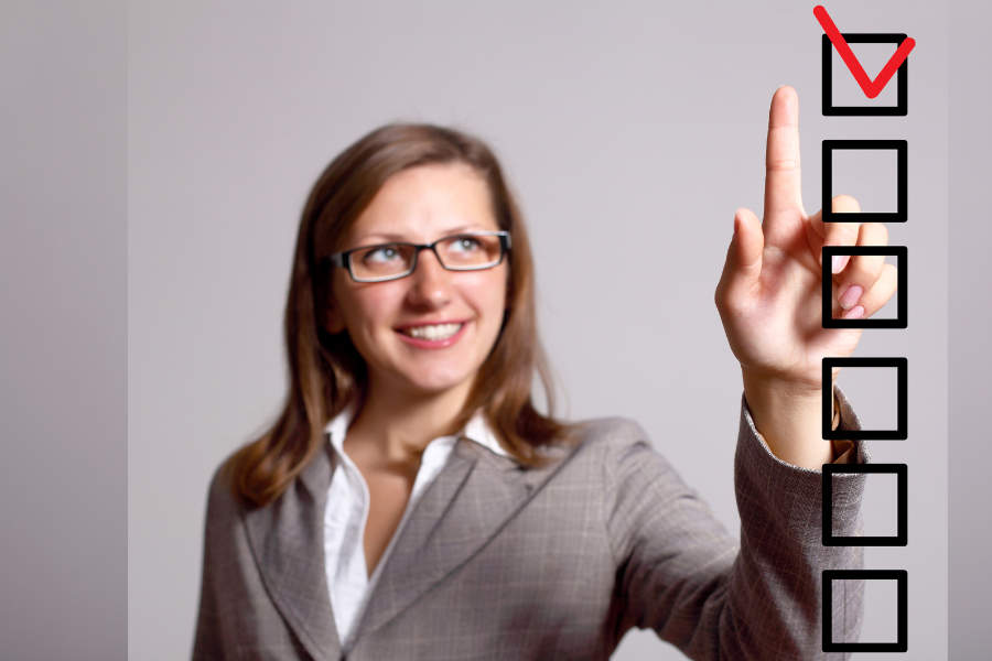 Link; Symbolbild für Bestandsaufnahme Startchancen-Programm (Foto/Grafik: Frau in Businesskleidung zeigt auf ein rotes Häkchen in einer vertikalen Checkliste.)