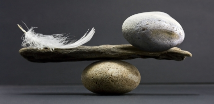 Symbolbild: Feder und Stein gleich schwer