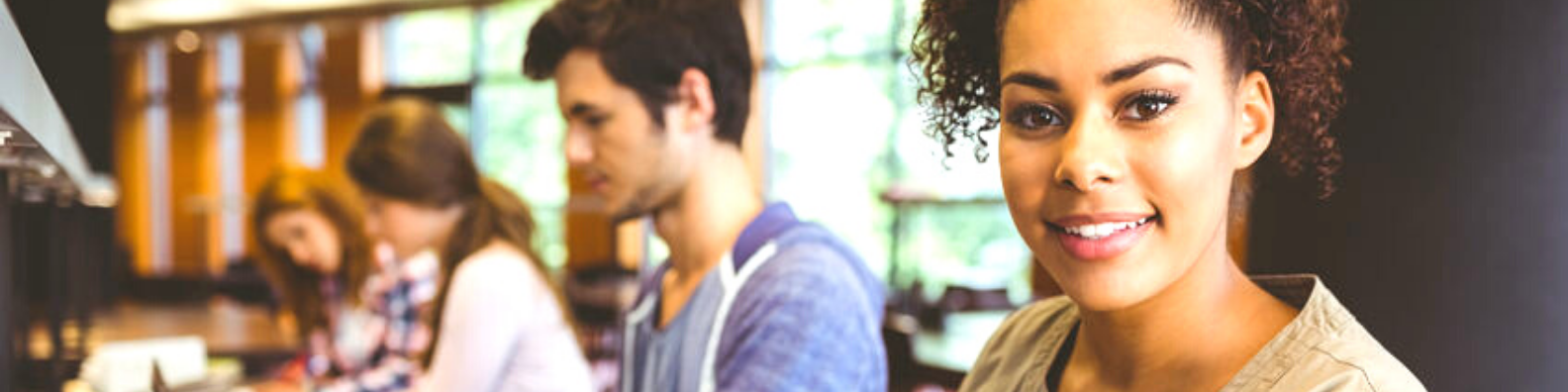 Foto: jugendliche Schülerin und weitere Schüler im Computerraum