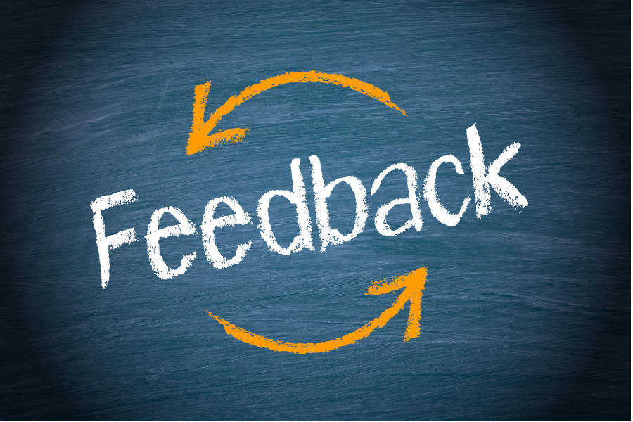 Link; Symbolbild für QUBE-F – Unterricht gemeinsam weiterentwickeln (Grafik: Auf einer dunkelblauen Tafel steht das Wort „Feedback“, umgeben von zwei kreisförmigen Pfeilen, die Austausch, Rückmeldung und Lernkreislauf symbolisieren.)