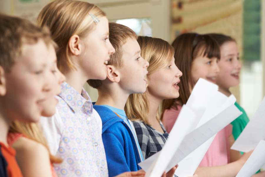 Link zur ZSL-Seite „Musik und Schulmusik“; Symbolbild für Musik (Foto: Gruppe von Mädchen und Jungen, die singen und Notenblätter in den Händen halten)