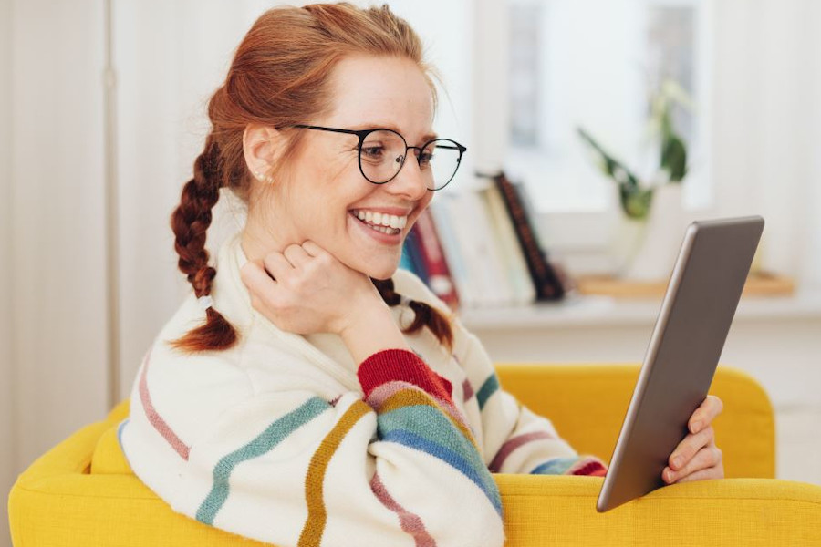 Link zur ZSL-Seite „BNE-Ressourcen“; Symbolbild: Informiert sein (Foto zeigt eine Frau, die in einem Sessel sitzt und auf ein Tablet schaut)