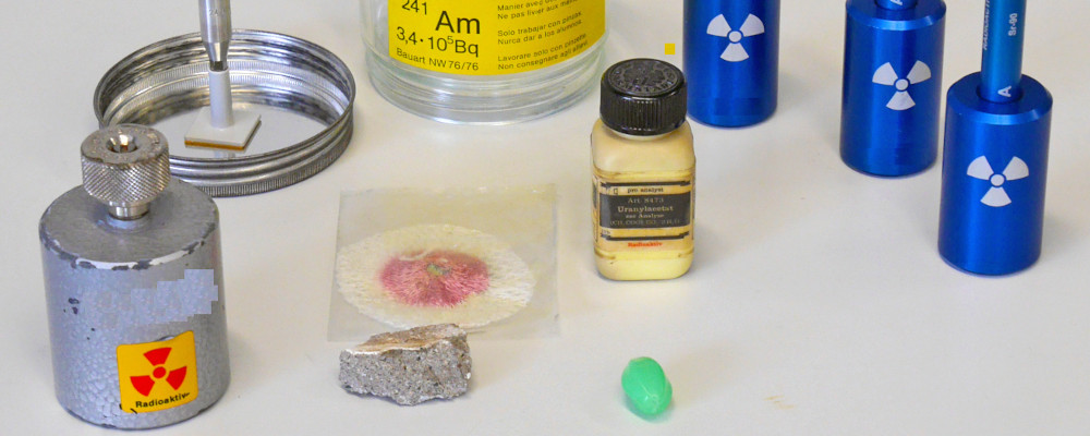 Foto: Auf einem Experimentiertisch stehen verschiedene radioaktive Präparate.