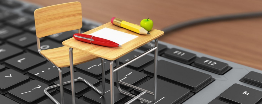 Einsatz digitaler Medien im Fachunterricht; Foto: Schülerpult und -stuhl im Miniaturformat auf Computertastatur