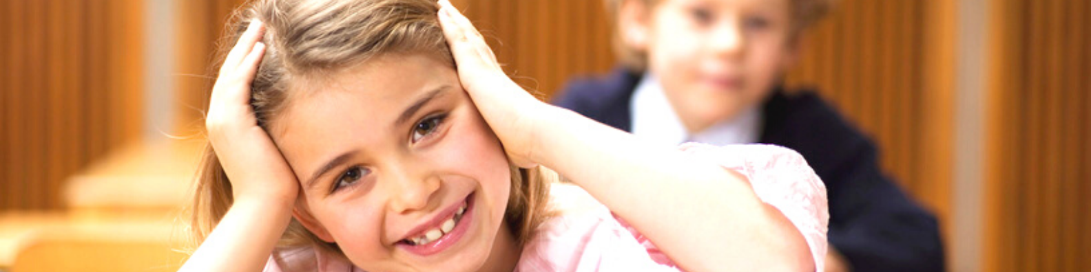 Foto: Grundschülerin, die etwas verzweifelt angesichts eines Stapels mit Lernheften ist