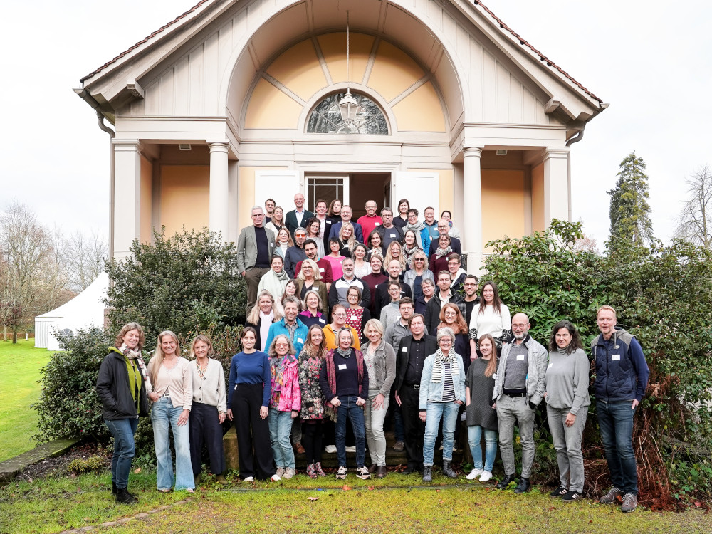 Gruppenfoto von Personen, die am Landesprogramm Kulturschule Baden-Württemberg beteiligt sind: über sechzig Personen stehen auf den Stufen einer Freitreppe zu einem klassizistischen Gebäude; sie blicken freundlich in die Kamera.