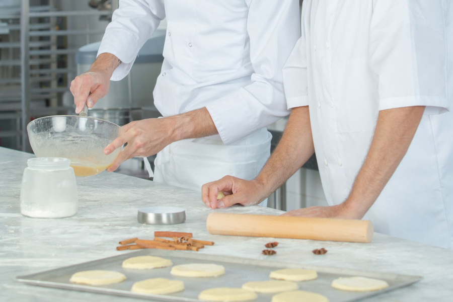 Link zur Seite Berufliche Eingliederung (Foto: zwei Personen beim Backen; man sieht nur die Arme)