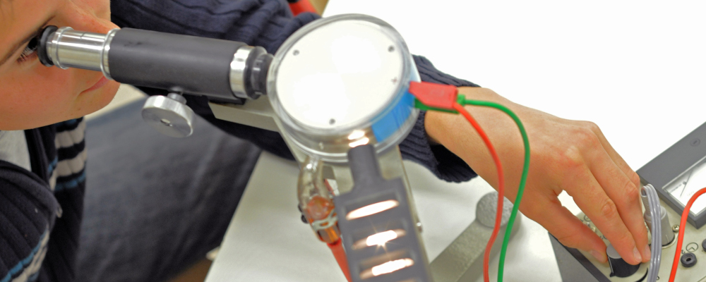 Foto: Ein Schüler eperimentiert im Physikunterricht.