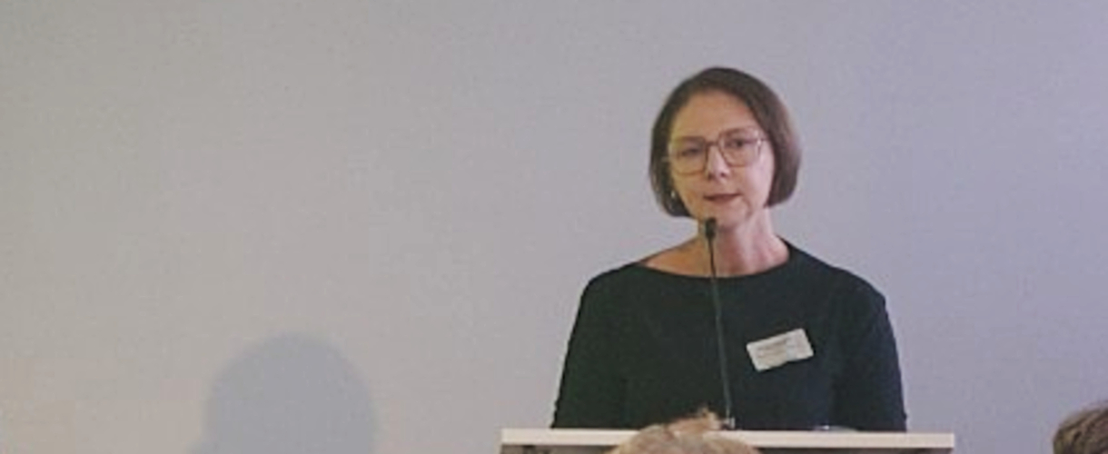 Fachtagung, Berlin 25.09.2025: Foto von Sandra Boser MdL (Sie spricht am Rednerpult in das Mikro. Sie trägt Brille, relativ kurze, dunkle Haare und ein schwarzes Oberteil.)