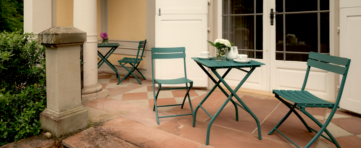 Foto: Außenansicht der Terrasse von Schloss Rotenfels mit einer grünen Gartensitzgruppe