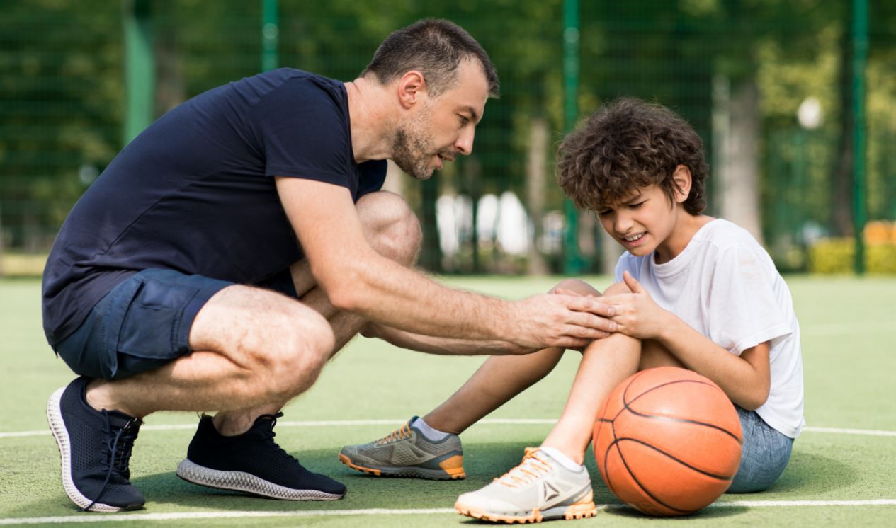 Foto: Sportlehrer hilft verletztem Kind