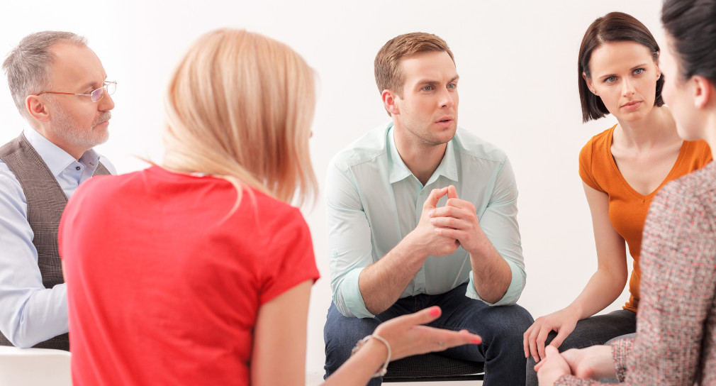 Symbolbild Psychologische Schulberaterinnen und Schulberater: Fünf Psychologische Schulberaterinnen und Schulberater beraten sich. Die Gesprächsatmosphäre ist aufmerksam, ernst und respektvoll.