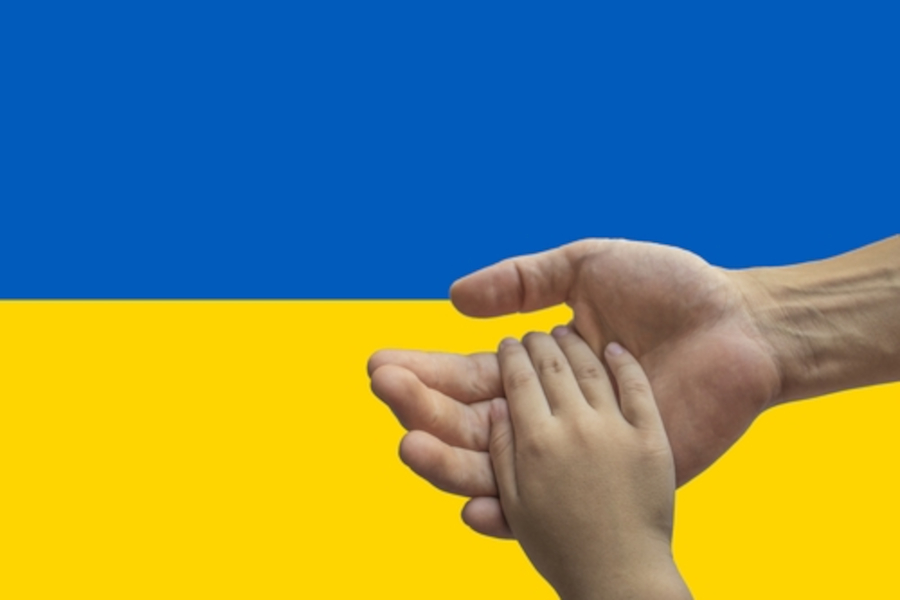 Link zur ZSL-Seite Geflüchtete Kinder und Jugendliche in der Schule (Foto: erwachsene Hand hält Kinderhand vor ukrainischer Flagge)