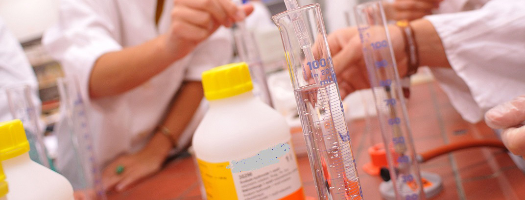 Foto: Auf einem Experimentiertisch stehen Standzylinder und Chemikalienflaschen. 