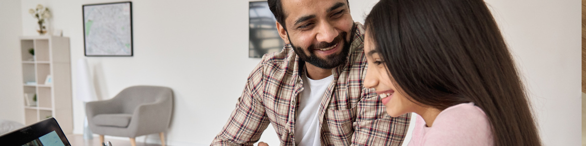 Foto: Vater und Tochter am Laptop im Wohnzimmer